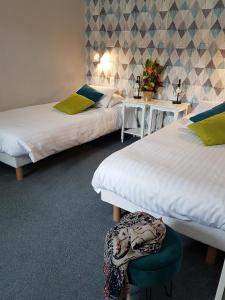 索姆河畔的圣瓦列里皮卡尔迪亚酒店的一间设有两张床、一张桌子和一把椅子的房间