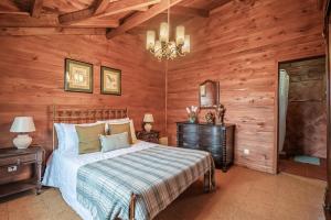 桑塔纳Villa Achada da Mouca by Madeira Sun Travel的一间卧室设有一张床和木墙