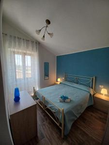 维泰博L'Acero di STALL的一间卧室设有一张床和蓝色的墙壁