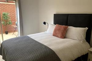 珀斯Modern 2 Bedroom Apartment in Perth的一间卧室配有一张带黑色床头板的床