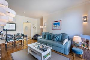 丰沙尔Atlantic Ocean View Apartment的客厅配有蓝色的沙发和桌子