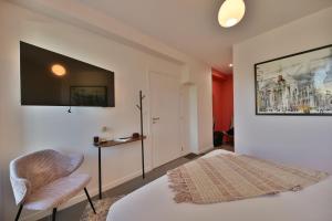 普罗旺斯地区萨隆Monte Alta的卧室配有一张床,墙上配有电视。