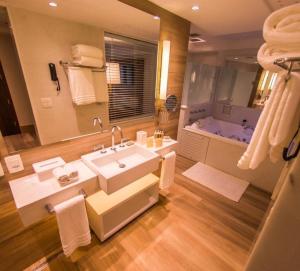 纳塔尔Vogal Luxury Beach Hotel & SPA的一间带大水槽和浴缸的浴室