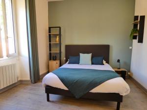 孔佛朗Logis Hôtel Emeraude的一间卧室配有一张带蓝色枕头的大床