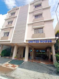 舍地Hotel United House的白色的建筑,上面有统一的房屋标志