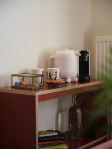 布鲁日Rûte - Bed no Breakfast的一个带咖啡壶的书架和杯子