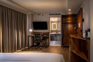 纽约La Quinta by Wyndham Time Square South的酒店客房配有一张床、一张书桌和一台电视。