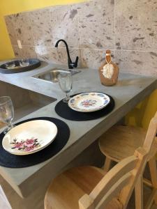 瓦哈卡市Casa Monarca的厨房柜台,配有两个盘子、玻璃杯和水槽