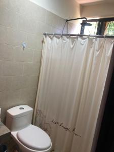 瓦哈卡市Casa Monarca的一间带卫生间和淋浴帘的浴室