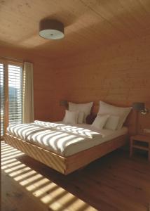 GrasbergDas Grasberghaus的卧室配有一张带白色床单和枕头的大床。