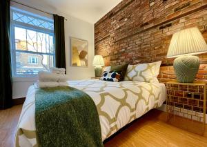 魁北克市PMTEEL的一间卧室设有一张床和砖墙