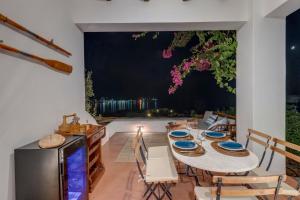 菲尼卡斯Cycladic Aura - Traditional Holiday Cottage的一间带桌椅和窗户的用餐室