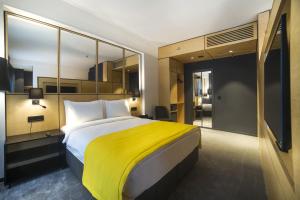 伊斯坦布尔Trip Park Hotel的一间卧室配有一张带黄色毯子的大床