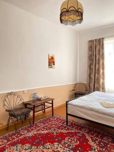 久姆里Unoyan Guest House的一间卧室配有一张床、一张桌子和一个窗户。