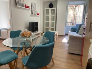 庞特维德拉HyP - A Casa do Correo Vello 1ºB的客厅配有玻璃桌和蓝色椅子