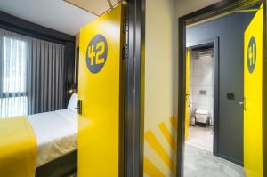 伊斯坦布尔Trip Park Hotel的一间设有黄色门和一张床的酒店客房