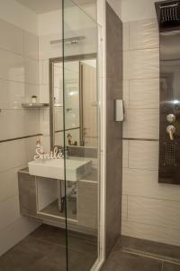 欧罗什哈佐Oros House Apartmanház的一间带水槽和淋浴的浴室