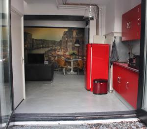 豪达Achterhuis Slapen en Eten的带桌子的厨房里的红色冰箱