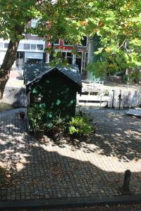 豪达Achterhuis Slapen en Eten的公园里种有植物的小黑狗房子