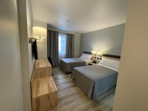 圣地亚哥Diego de Almagro Providencia Express的酒店客房设有两张床和电视。