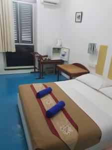 马六甲D Riverside Inn的一间卧室配有一张带蓝色枕头的床。