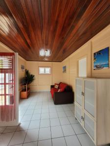 勒沃克兰La Maison du Pécheur 97280 vous propose 2 bungalow, 2 Piscine privé avec jaccuzi intégrés, a 5 min de la plage et 2 min du port de pêche的带沙发和木制天花板的客厅