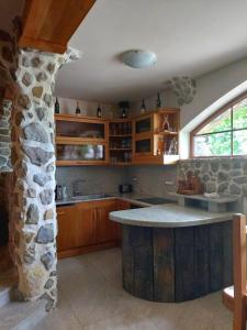 MirnaZerko Holiday Home - Vineyard Chalet With Sauna and Jacuzzi FREE的一个带石墙和石岛的厨房