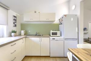普拉Homestay Pula的厨房配有白色橱柜和白色冰箱。