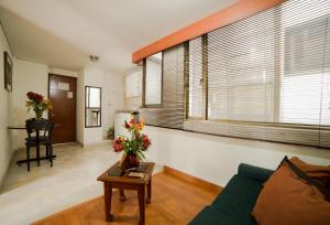 波哥大Apartamentos Galerías的客厅配有沙发和鲜花桌