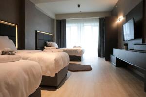 萨卡里亚Hotel54 Luxury Suite的酒店客房设有两张床和电视。