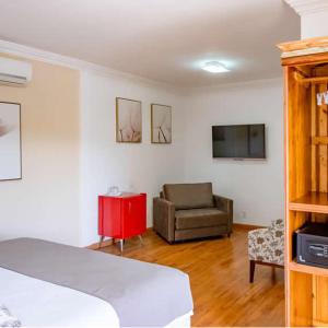瓦索拉斯Bliss Hotel Vale do Café的客房设有床、沙发和电视。