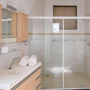 瓦索拉斯Bliss Hotel Vale do Café的带淋浴和毛巾水槽的浴室