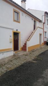 马尔旺Casa da Portagem by Portus Alacer的白色的房子,有楼梯和门