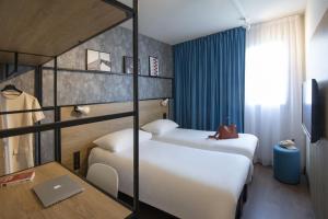 加普ibis Gap Centre的酒店客房配有两张床和一张书桌
