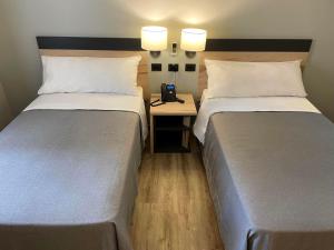 圣地亚哥Diego de Almagro Providencia Express的酒店的客房内设有两张床,中间设有电话