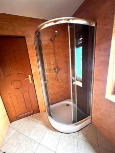 KoszarawaPensjonat Sabina的浴室里设有玻璃门淋浴
