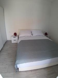 皮罗瓦茨Apartments with a parking space Pirovac, Sibenik - 17653的一张白色的床,房间有两个床头柜