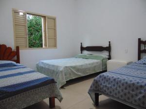 卡皮托利乌Rancho do Pedro的一间卧室设有两张床和窗户。