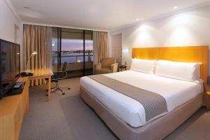 珀斯珀斯皇冠假日酒店的酒店客房配有一张床、一张书桌和一台电视。
