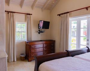 圣詹姆斯Bianca Bay 3 Bedroom West Coast Beach Front Villa的一间卧室配有一张床、梳妆台和电视。