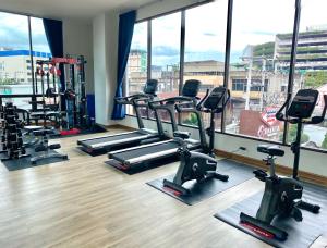乌隆他尼Banbua Grand Udon的健身房设有数台跑步机和大窗户