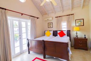 圣詹姆斯Bianca Bay 3 Bedroom West Coast Beach Front Villa的一间卧室配有红色和黄色枕头的床