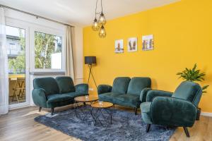 沃尔夫斯堡FREE LIVING - Jungle Design Apartments, Zentrum, Parkplatz, Küche, Wlan的客厅设有绿色家具和黄色墙壁