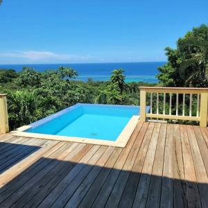 罗阿坦Turquoise view villa with pool!的甲板上的游泳池,背景是大海