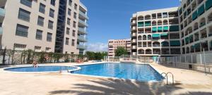 拉皮内达vacaciones en pineda con 2 piscinas, playa a 5 min的两栋建筑中间的游泳池