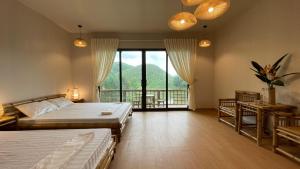 Yen BaiOMTARA RETREAT的一间带两张床和阳台的大卧室