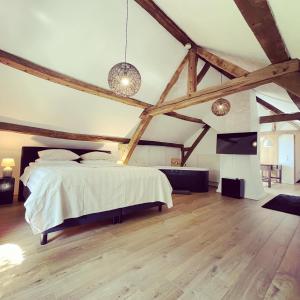 海尔伦Hoeve Berghof的一间卧室设有一张大床,铺有木地板。