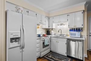 大西洋滩Southwinds C8的厨房配有白色橱柜和冰箱。