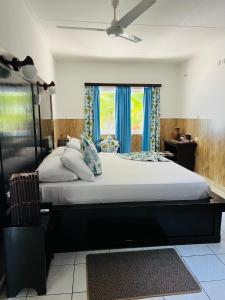 Anse Kerlan开普吉恩玛丽海滩别墅的一间卧室配有一张带蓝色窗帘的大床