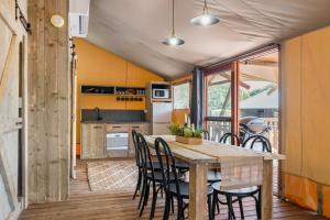 巴利纳Ballina Beach Nature Resort的厨房以及带木桌和椅子的用餐室。